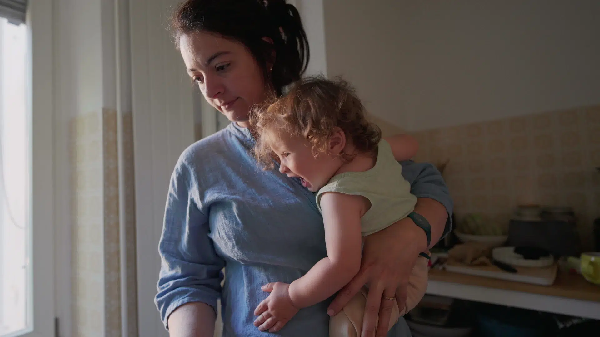 Femme tenant un enfant dans une cuisine
