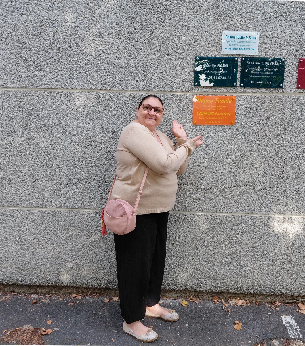 Femme devant des plaques sur un mur Femme pointant des plaques professionnelles